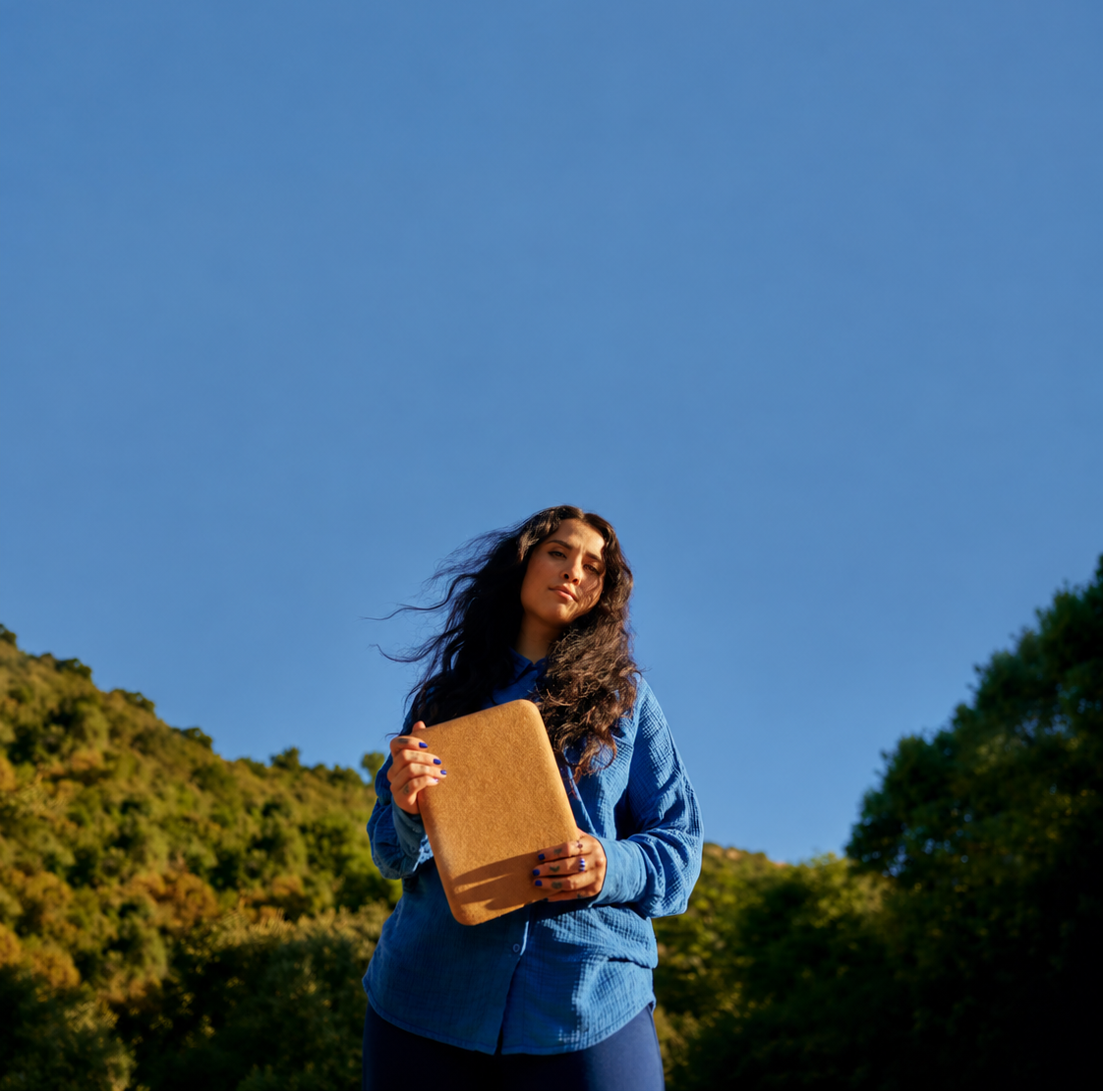 Wren Ashlee holding Halo outdoors against a clear sky