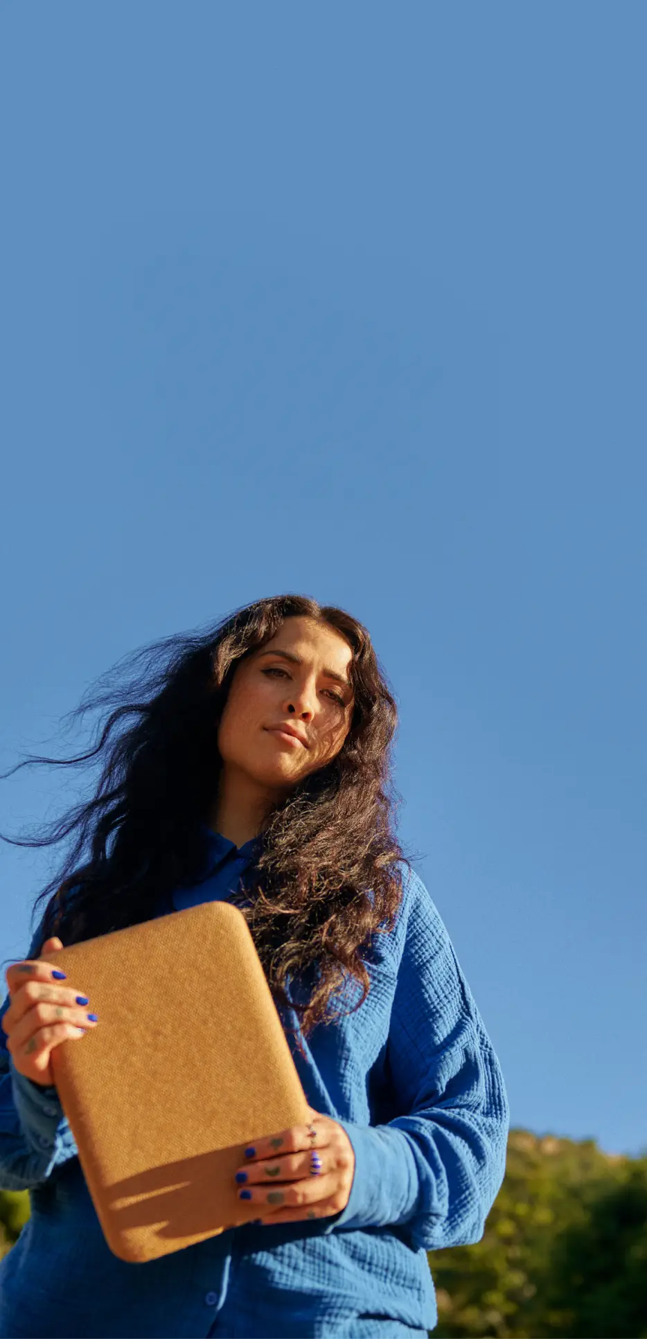 Wren Ashlee holding Halo outdoors against a clear sky